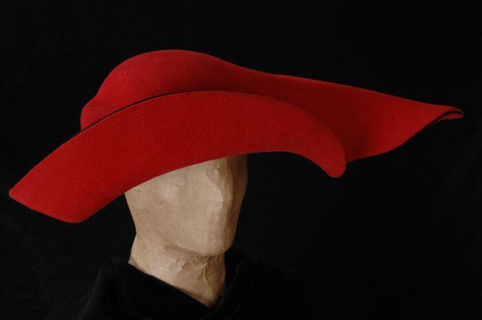 Hoed van rood vilt met zwarte tussenlaag in a-symmetrische vorm, "Liesbeth Snijders Hoeden"