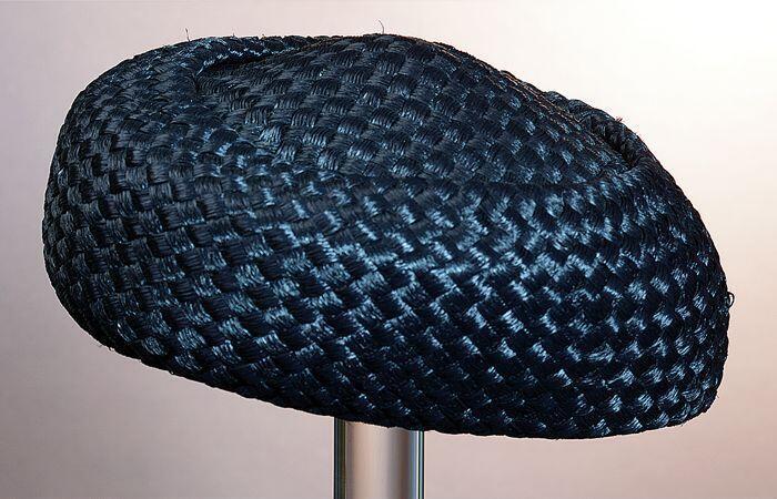 Ronde zwarte pillbox, raffia bol ligt iets verdiept