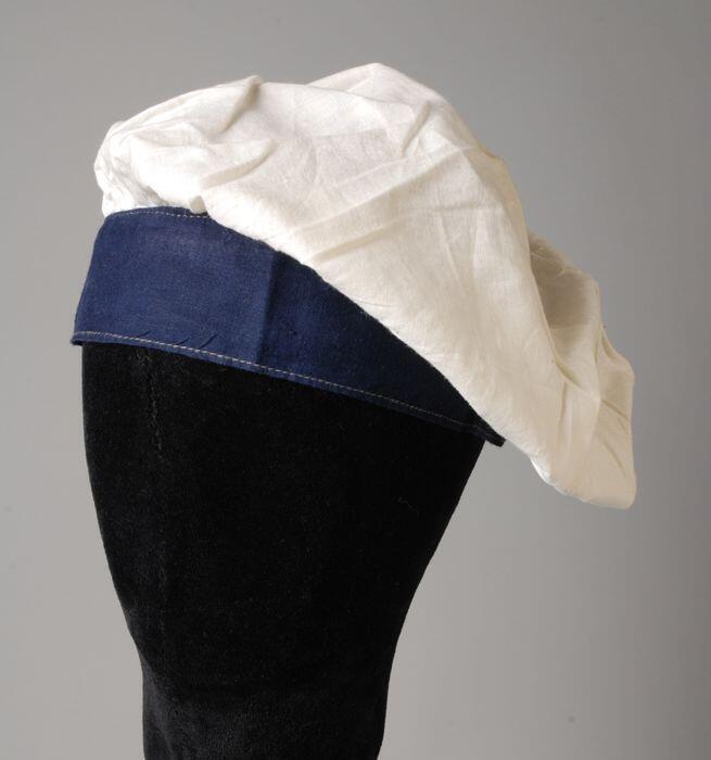 Muts, wit katoenen bol gerimpeld aan een blauwe band