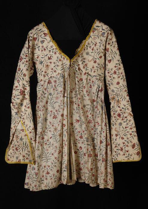 Caraco of jak van sits, wit fond met kleurige bloemranken die een ruitpatroon vormen, hoge taille,…