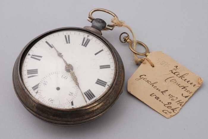 Zakhorloge met wit-emaille wijzerplaat en gouden wijzers met stofkap in buitenkast en opwindsleutel…