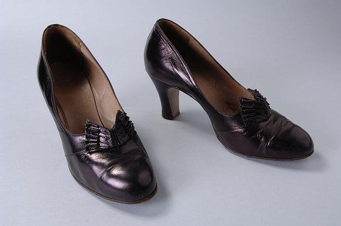 Leren pumps in auberginekleur met metaalglans, ronde en bolle neus, sierstrik op de voorvoet, hoge…
