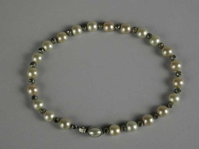 Armband van kleine iets afgeplatte parels en facetgeslepen stenen in zilveren zettin, om-en-om aan…