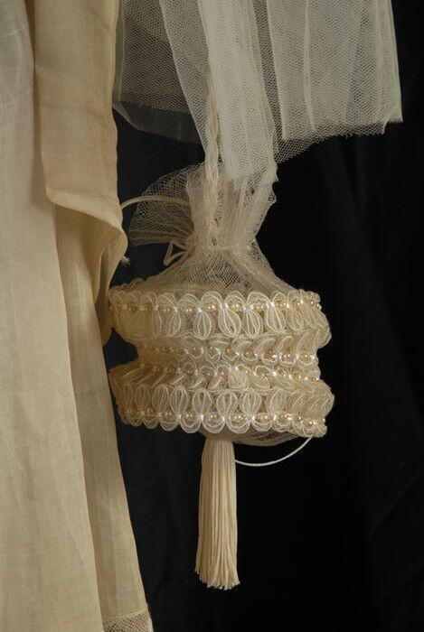 Reticule of buideltasje van wit kunststoflaiton en gaas bezet met imitatieparels en onderaan witte…