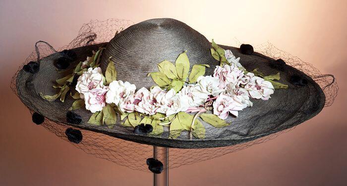 Grote ronde dameshoed met roze bloemen met groene blaadjes