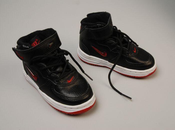 Zwarte leren kindersportschoenen, zool rood met witte rand, rode merktekentjes, merk Nike, met…