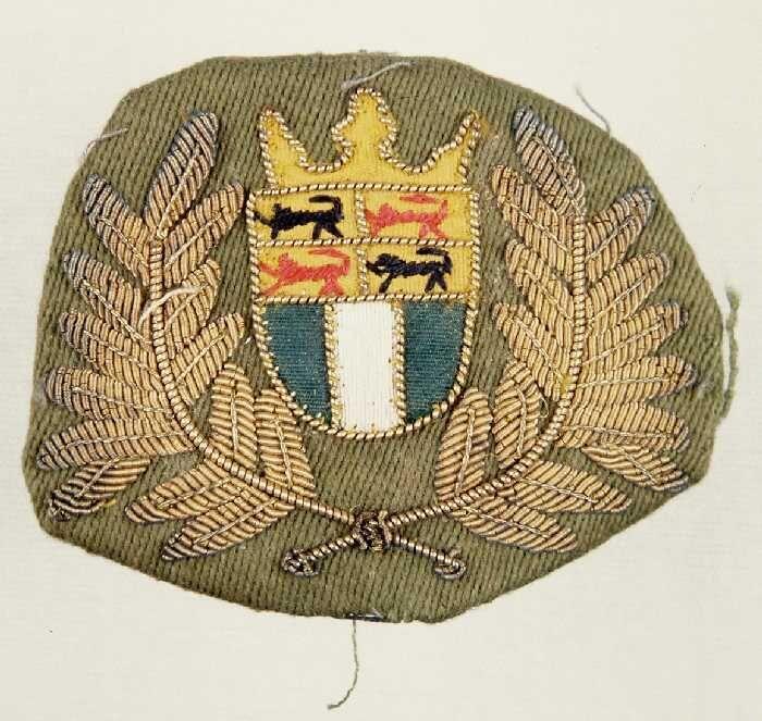 Embleem, legergroen keperkatoen met geborduurd wapen van Rotterdam en omgeven door lauwerkrans,…