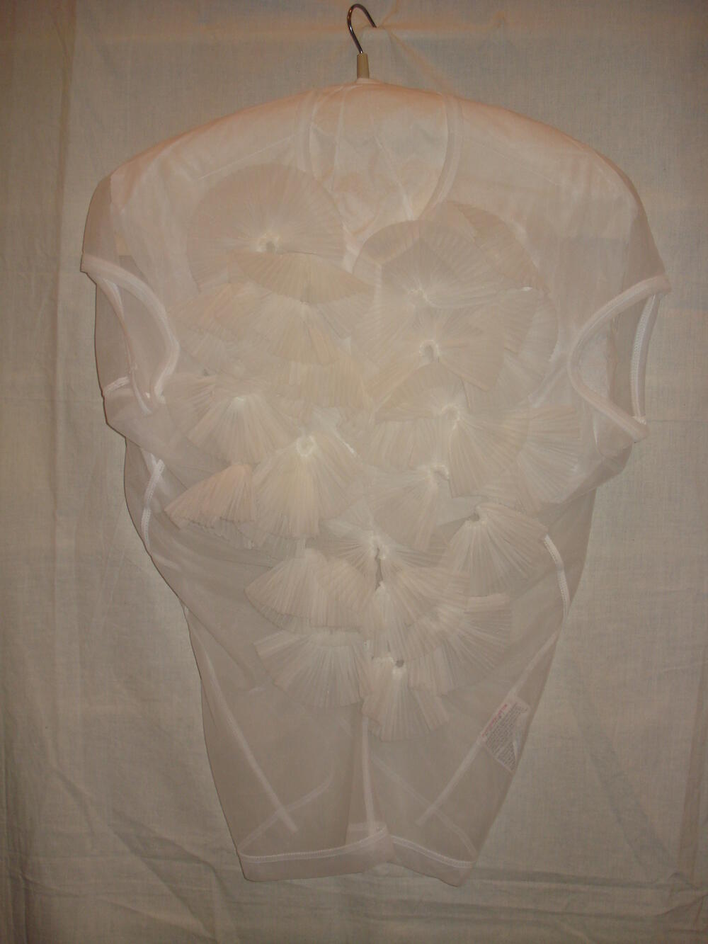 Top, mouwloos, bestaande uit vier schuingeknipte panden van transparant wit nylon tricot, midden…