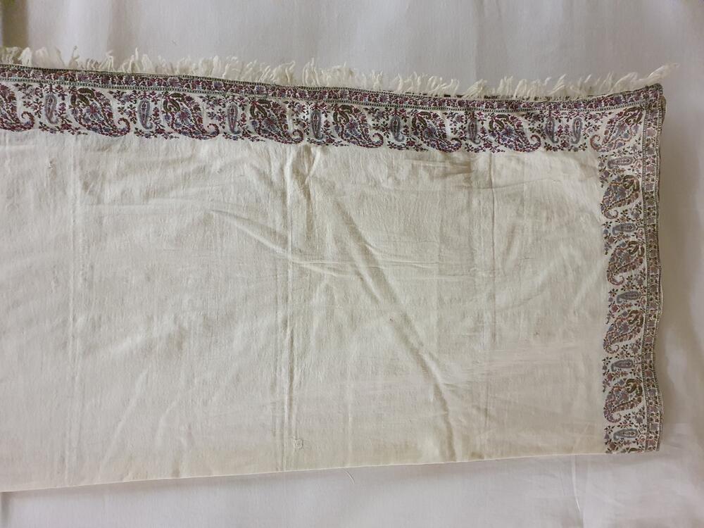 Shawl van witte wol, rondom gegarneerd met rand van kashmirpatronen in oudroze, blauw, geel,…