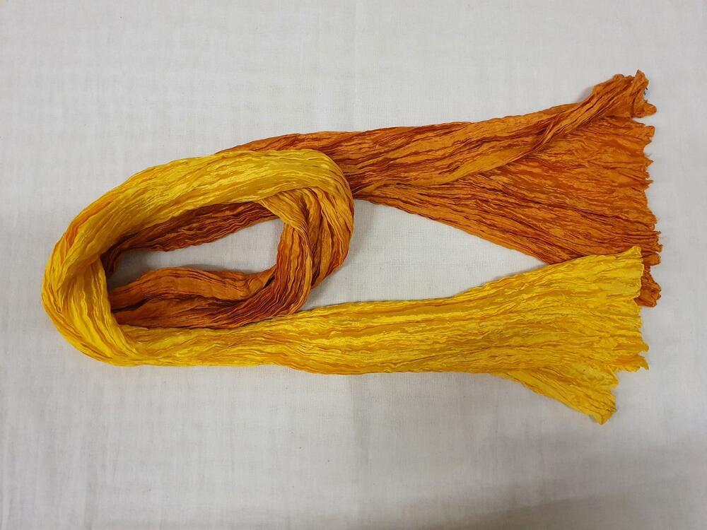 Sjaal van gekrinkelde, glanzende oranje/gele viscose. Recht model in oranje/geel dégradé