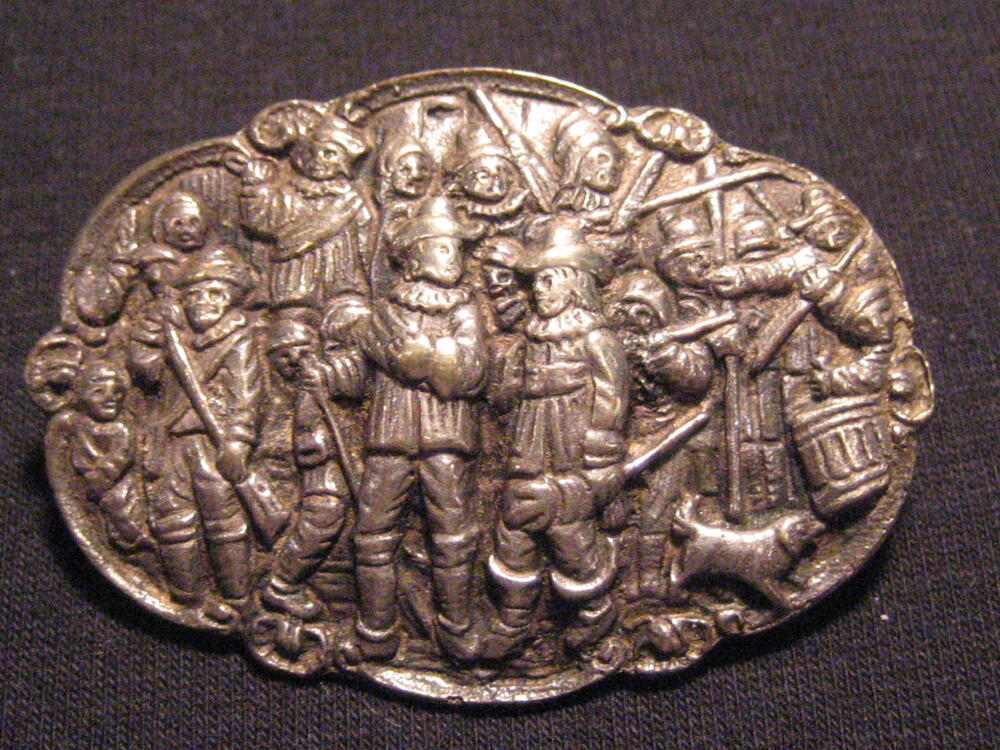 Ovale zilveren broche met geschulpte rand en in midden voorstelling van Rembrandts 'Nachtwacht'