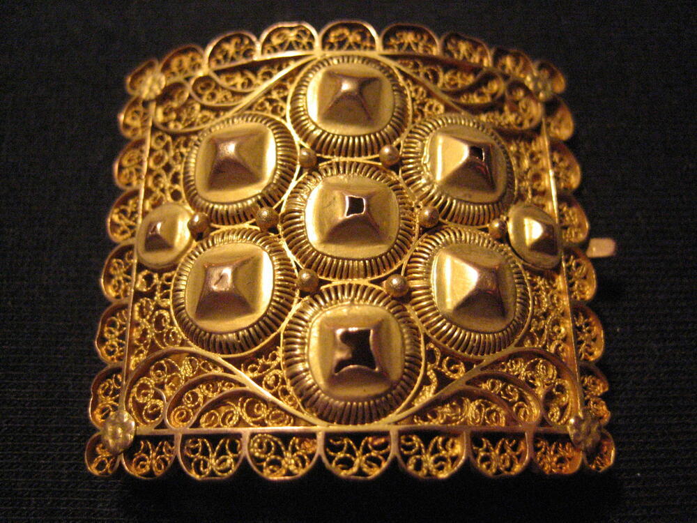 Gouden slot van halssnoer. Vierkant model met rozetten, pyramidevormen en filigrainwerk