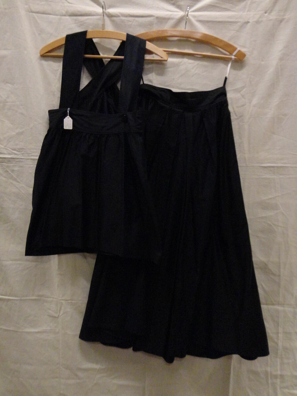 Ensemble of tweedelige zomerjurk van zwart glanskatoen, bestaande uit een mouwloze top en 
een…