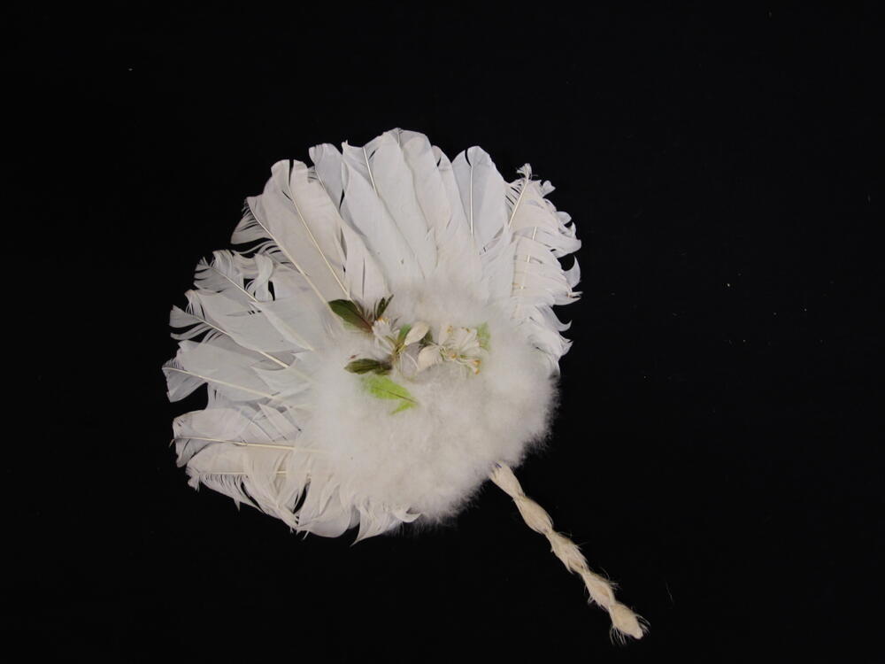 Waaier, rond blad van witte veren met in het midden zwanendons, waarop garnering van gekleurde…