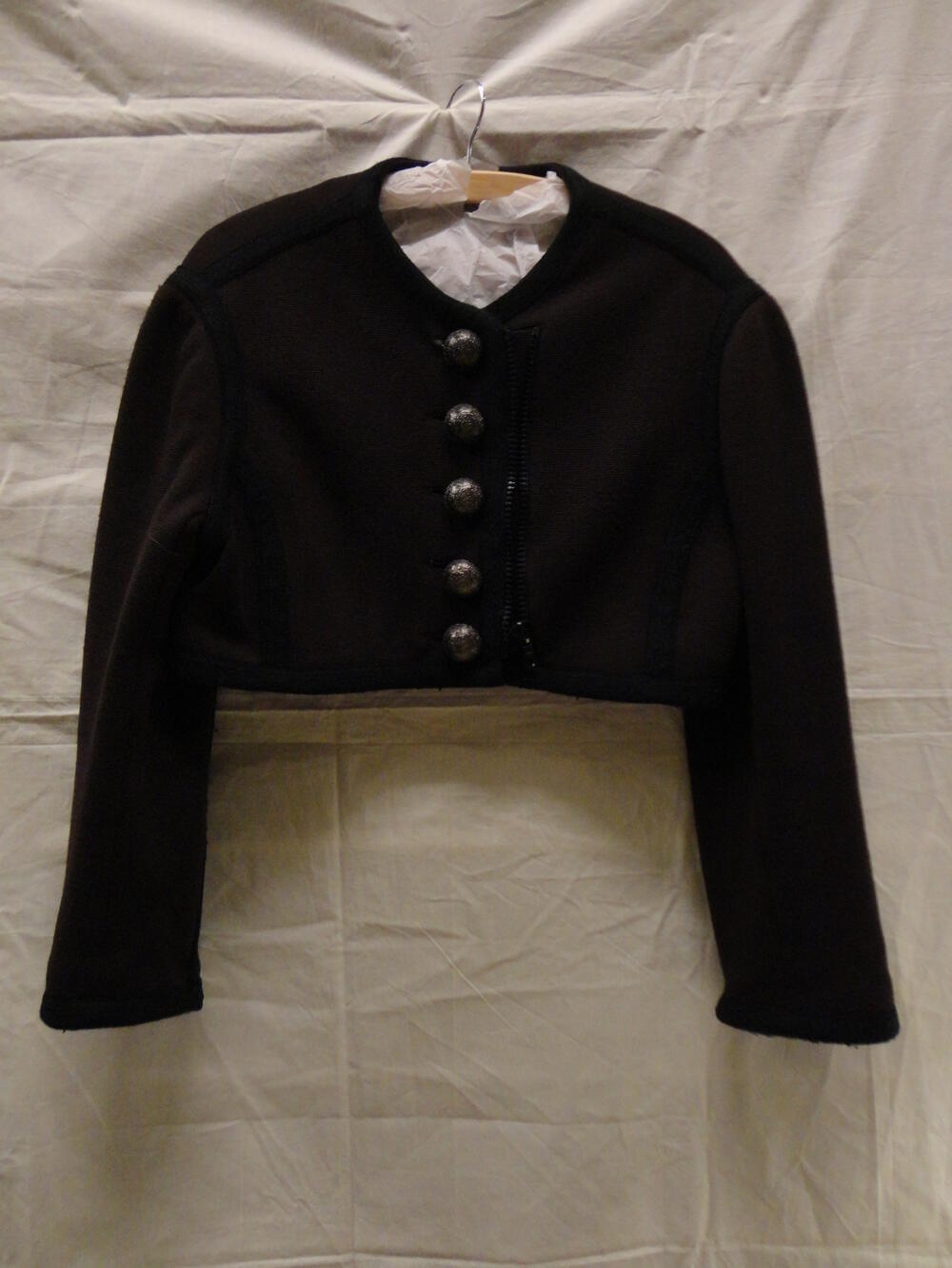 Bolero van bruin tricot, afgebiesd met zwart band