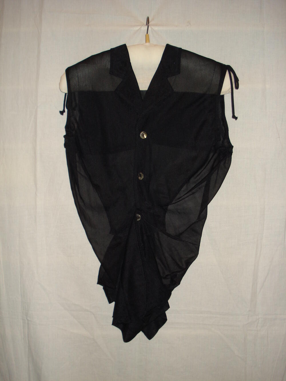 Vestje, mouwloos, bestaande uit vier panden van schuingeknipt transparant zwart nylon tricot,…