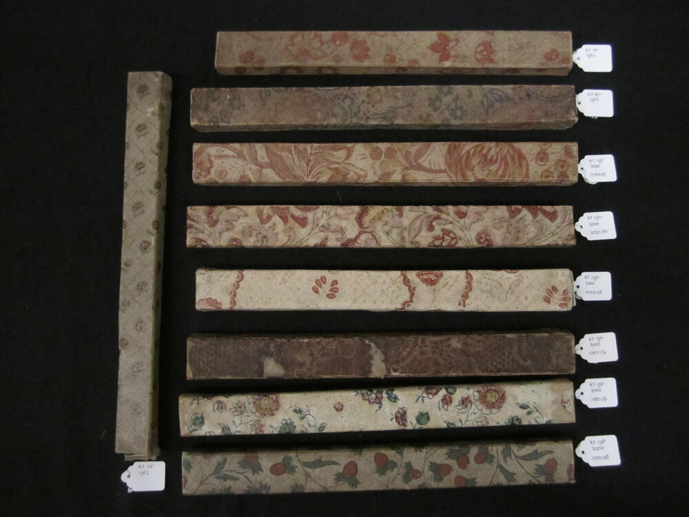 Waaierdoos van karton met rood/roze/zwarte bloemopdruk, binnenzijde beplakt met blauw papier