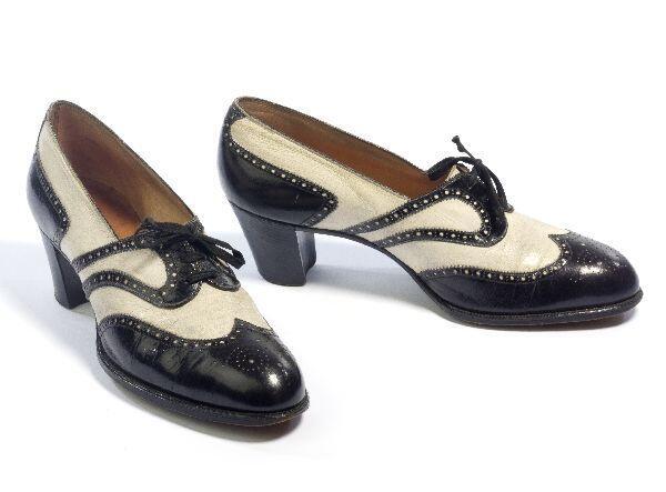 1 Paar schoenen (vrouw) van zwart en wit leer met half hoge hak en vetersluiting. Met brogue…