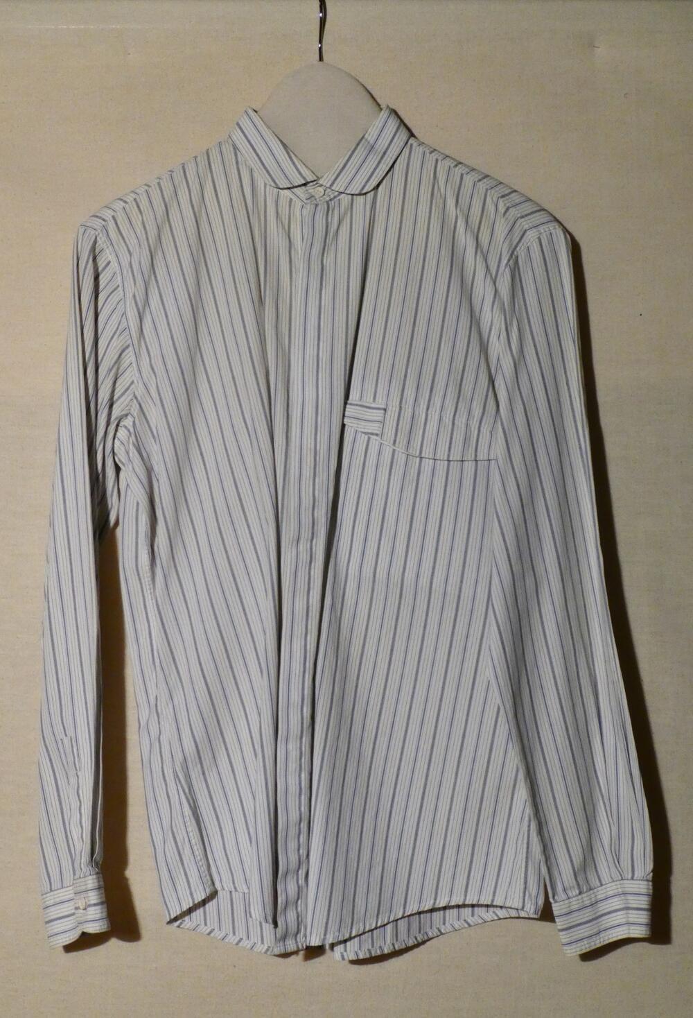 Overhemd (man) van wit katoen met ingeweven streepjes in diverse kleuren blauw. Kraag met ronde…
