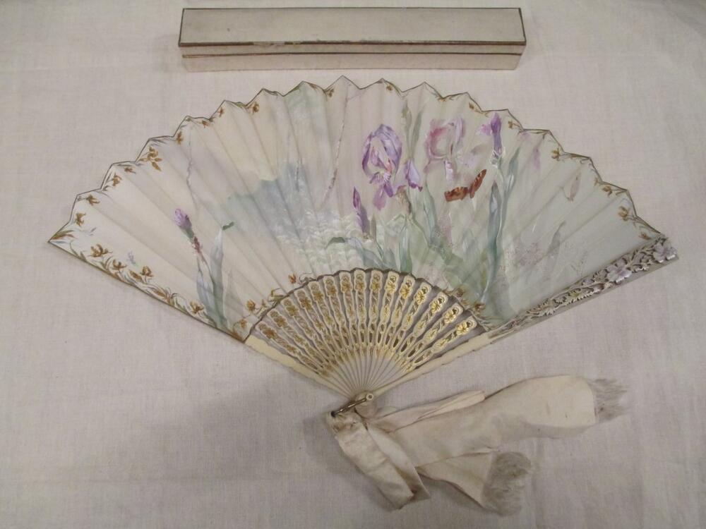 Vouwwaaier in doos, montuur van wit hout, zijden blad beschilderd met bloemen in lila