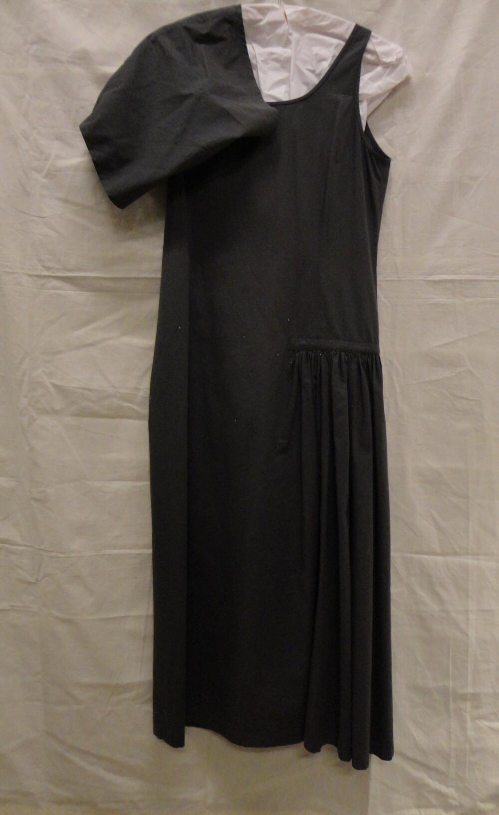 Jurk van donkergrijs mengweefsel van katoen en polyurethaan, asymmetrisch model met draperie over…