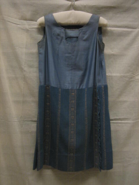 Jurk bestaande uit lijfje van blauw satinet met daaraan een rok van blauwe wol met ingeweven…
