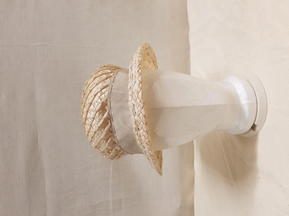 Hoed van lichtbeige gevlochten stro, waardoorheen stro gevlochten in diagonale lijnen, rond bol een…
