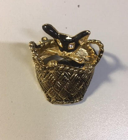Broche in de vorm van kat in mandje van goudkleurig metaal, kattenkopje met zwart emaille en witte…