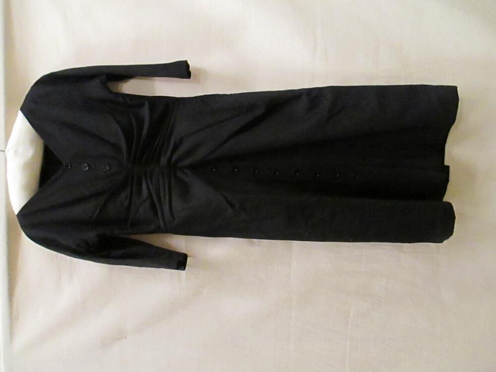 Jurk van zwarte wol met kunststof, 7/8 model met V-hals en 3/4 mouw. Middenvoor draperie en knopen…