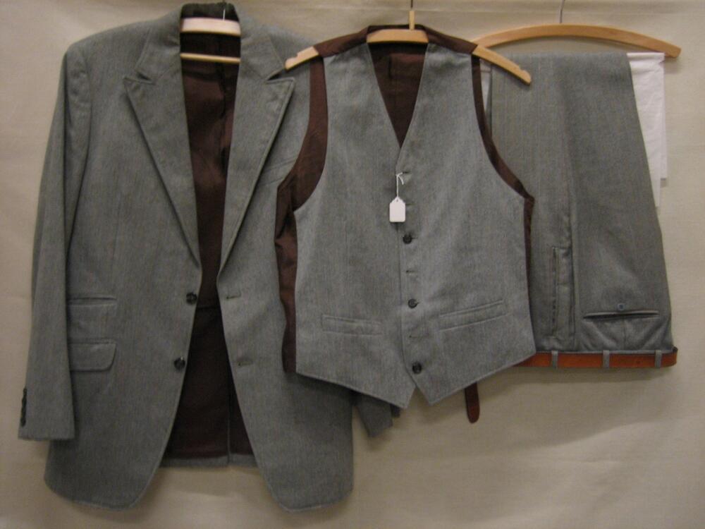 Driedelig pak van grijze wol met witte en gele streep, bestaande uit een jasje, vest en broek met…
