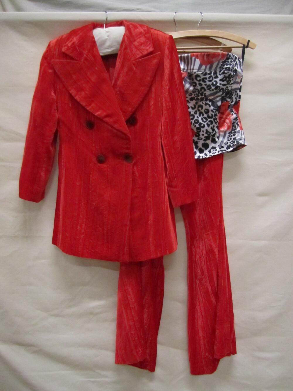 Broekpak van rood velours, jasje en lange broek met topje van satijn met fantasieprint van rozen en…