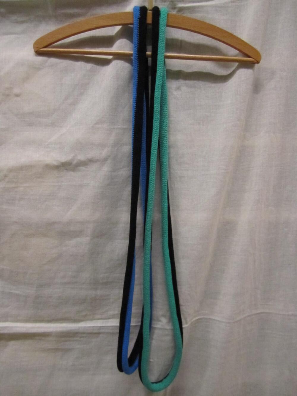 Twee cirkels van groen/zwarte en blauw/zwarte machinaal gebreide glanskatoen, te dragen als…