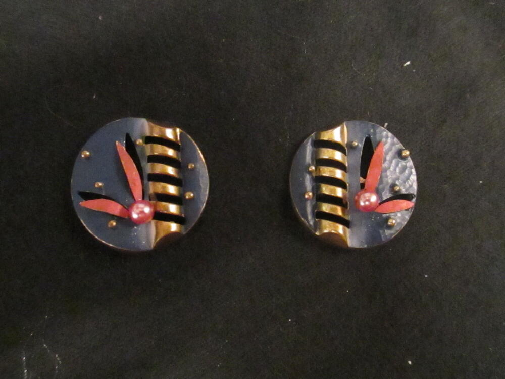 Oorclips, rond model van gehamerd en uitgezaagd messing, blauw fond met twee roze bladvormen en…