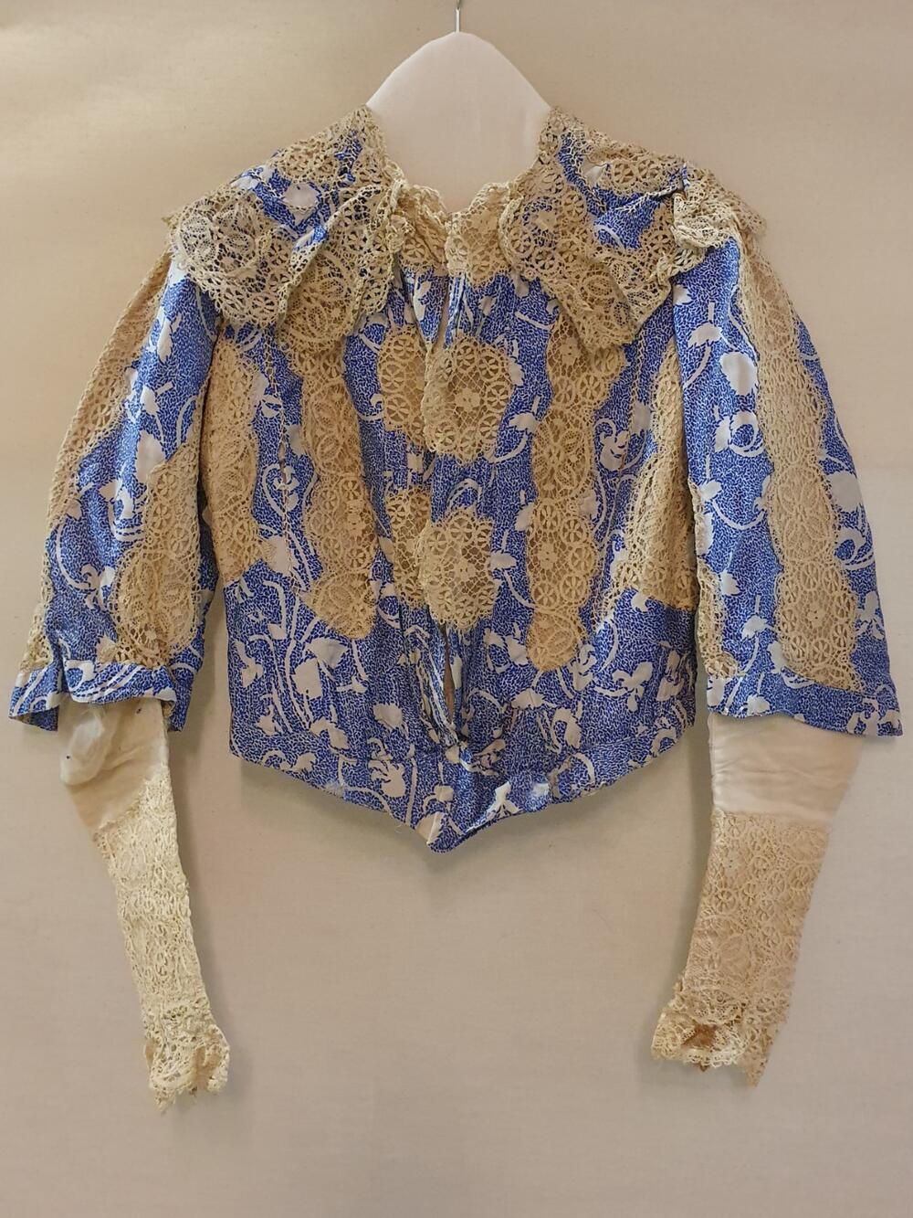 Japonlijfje van wit met blauw bedrukte foulardzijde, gegarneerd met crèmekleurig machinaal kant, de…