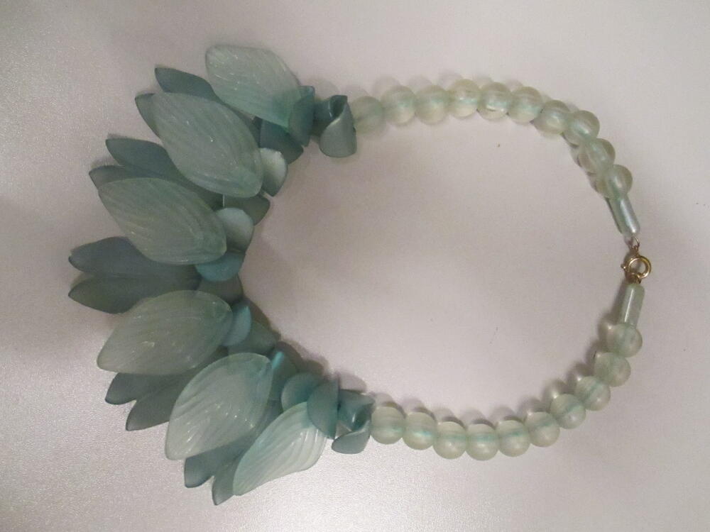 Ketting van transparante ronde kralen, gebogen schakels met mintgroene metallicglans en…