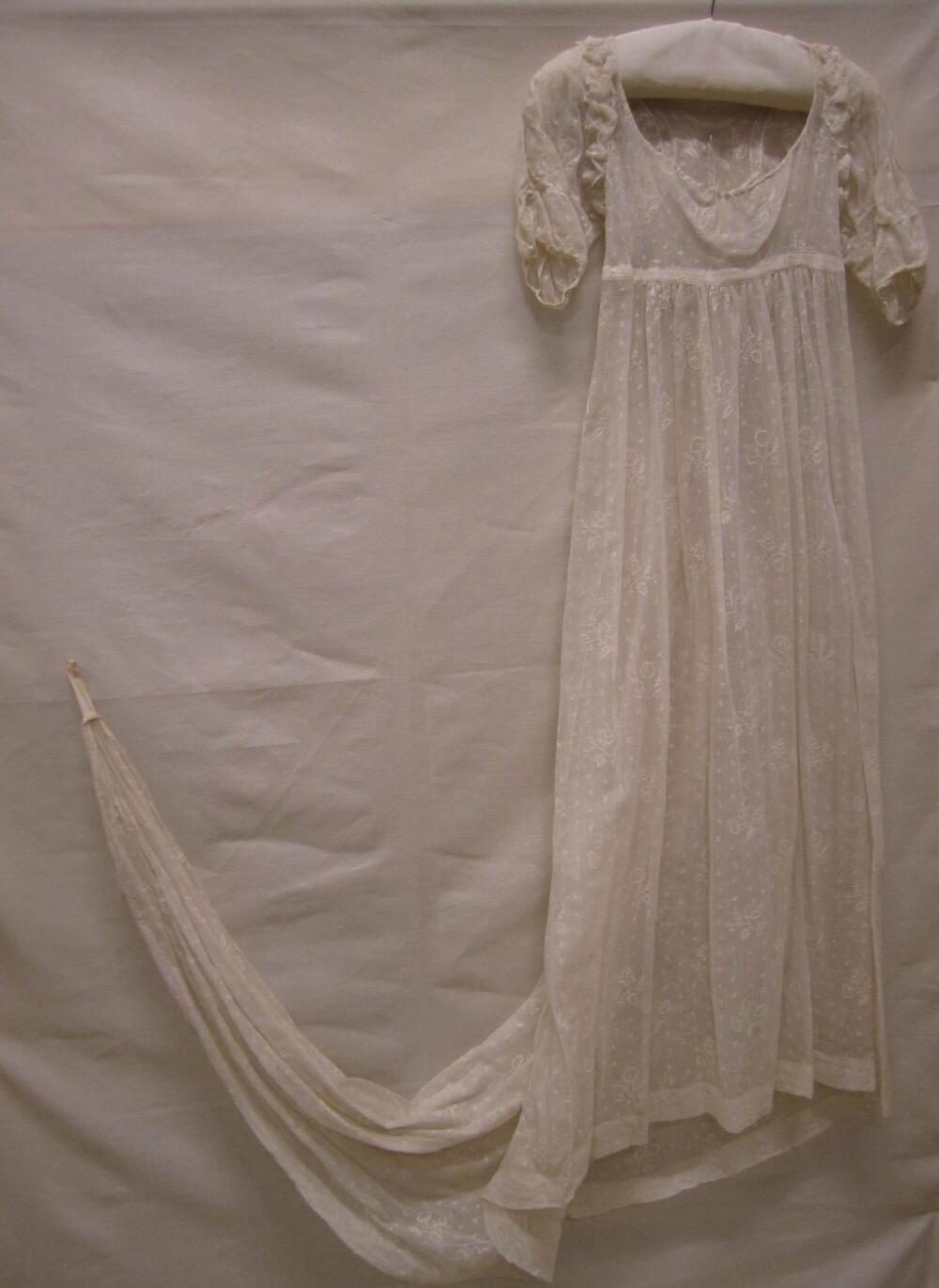 Japon, mogelijk avondjapon van witte katoenen mousseline of neteldoek met sleep, geheel geborduurd…