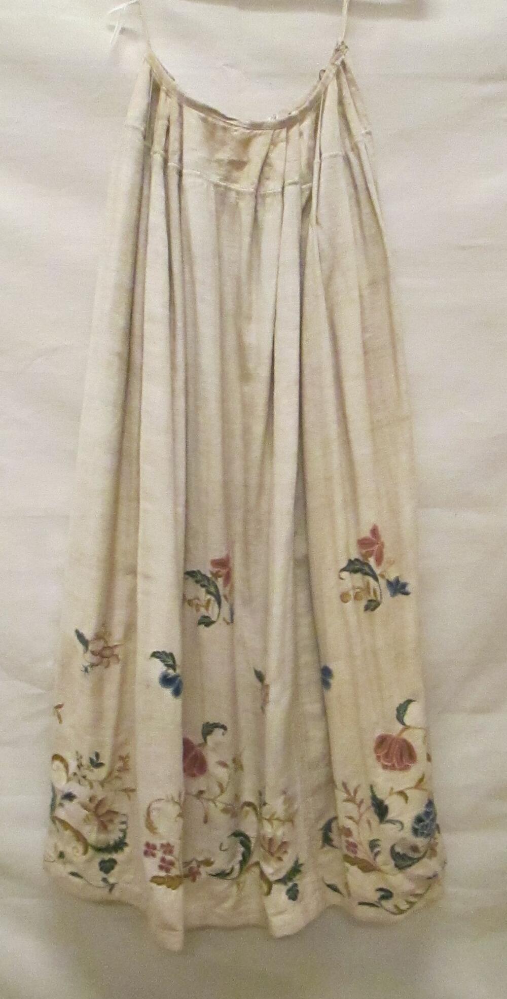 Rok van crèmekleurig keperkatoen met langs de rokzoom wolwerkborduursel, zogenaamd crewelwork, in…
