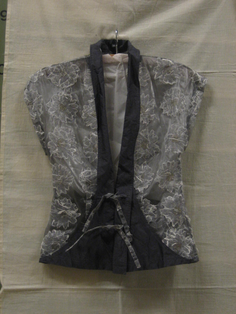 Blouse, deels transparant, van nylon, versierd met papieren bloemmotieven