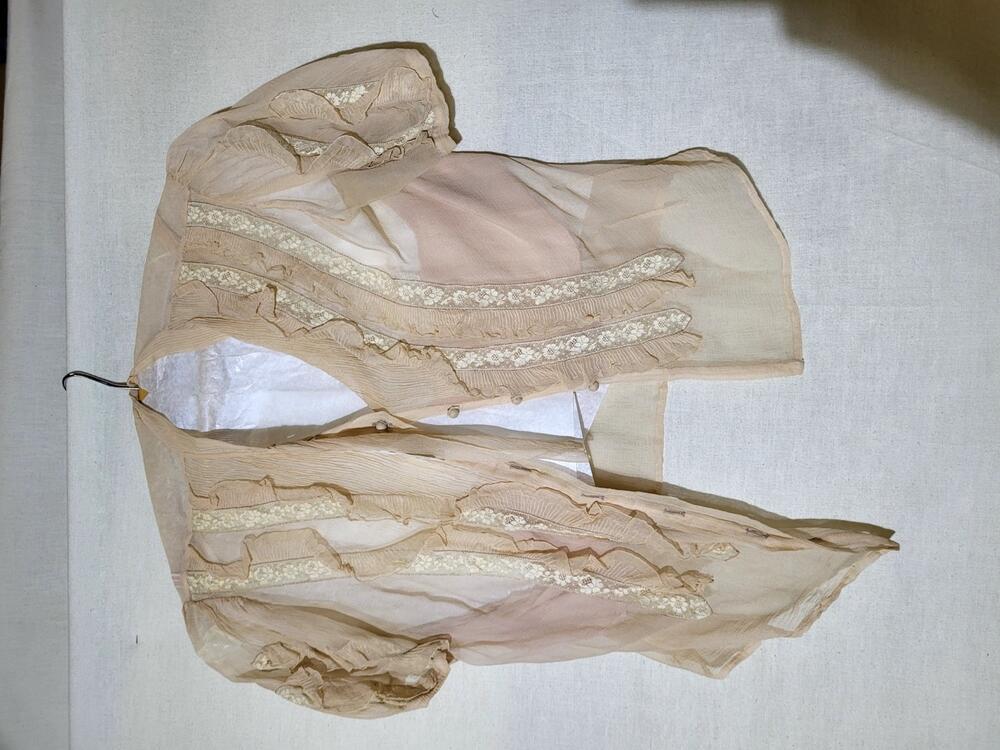 Blouse van zalmkleurige zijden crêpe, incrustaties van gebloemd kant met ruches