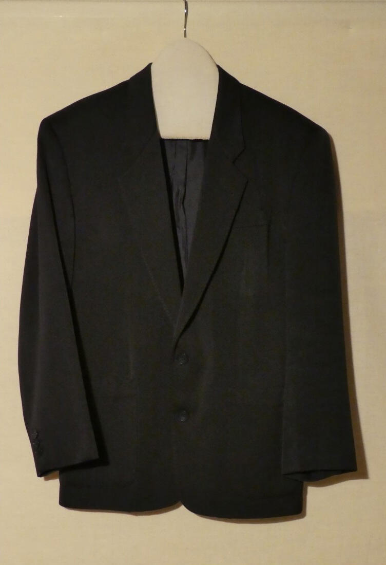 Blazer (man) van donkerblauwe wol. Brede schouders met schoudervulling. Kraag en revers op…