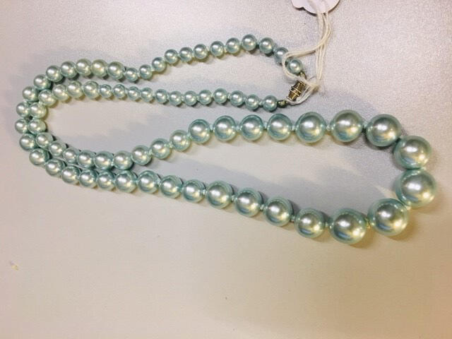 Ketting. Glas of plastic imitatie parels. Lichtblauw. Oplopend in grote.