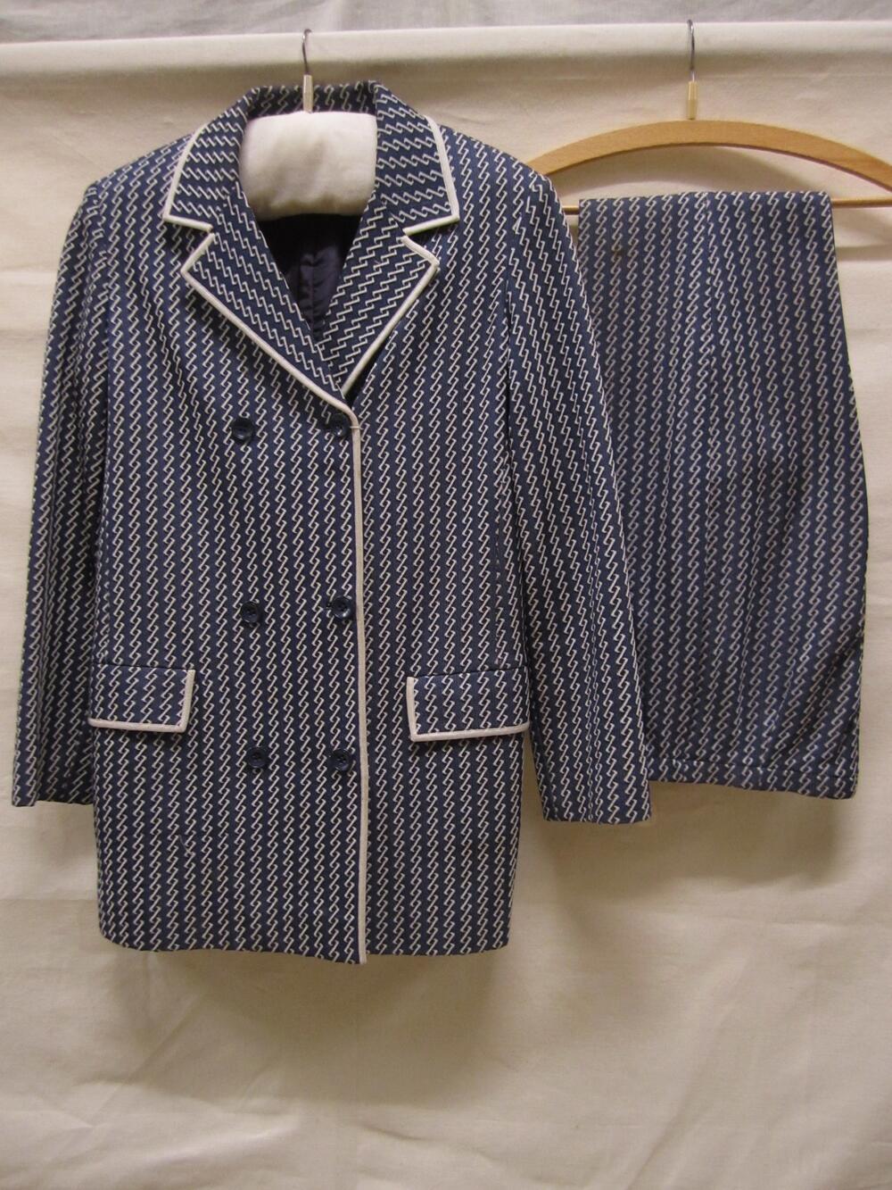 Broekpak van donkerblauwe wol met ingeweven zig-zag motieven in witte banen; jasje en lange broek