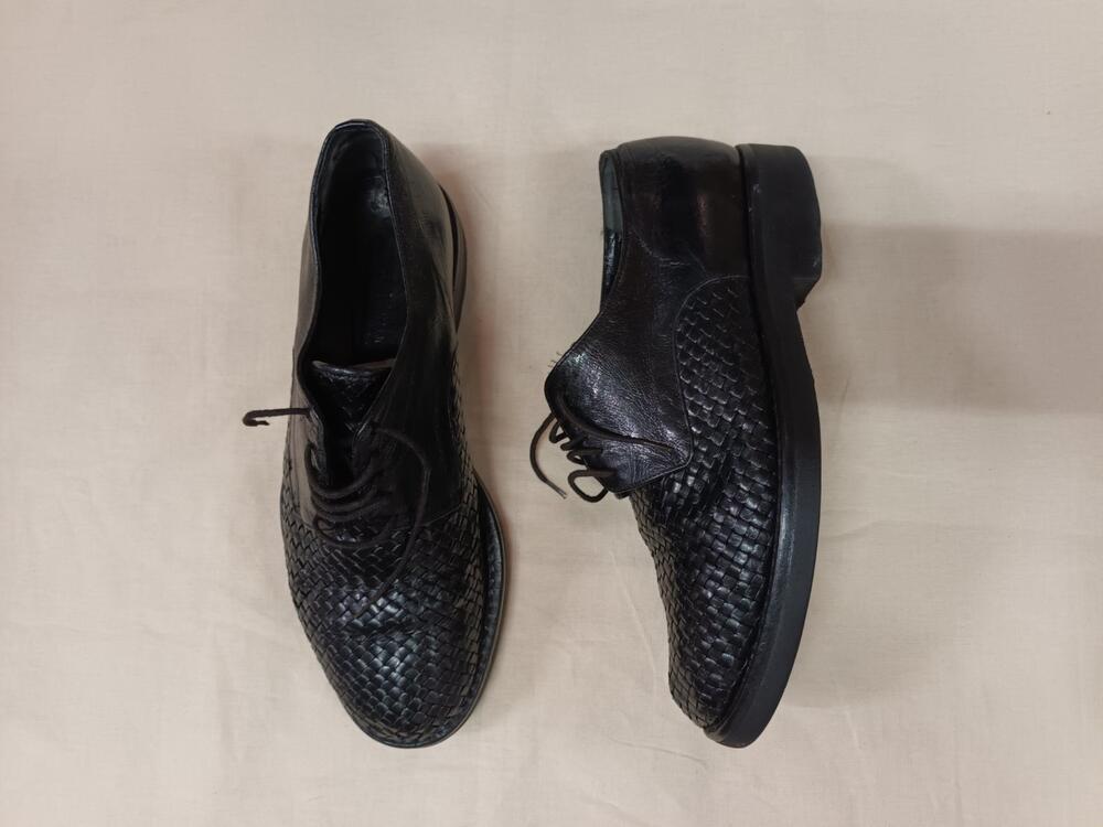 1 paar schoenen (man) van zwart leer, ovaal gevormde neus van gevlochten zwart leer en achterkant…