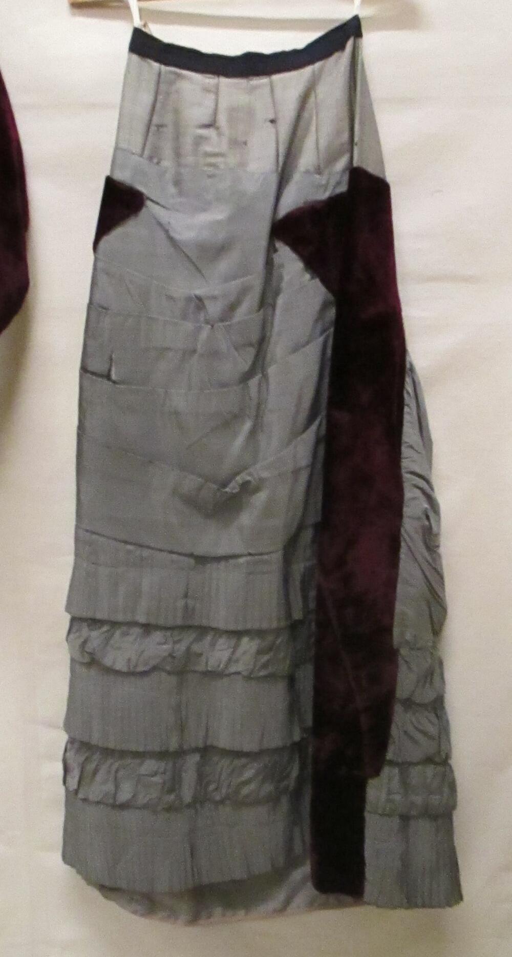 Japonrok van donkerrood zijdefluweel en stroken en draperieën van grijze zijde op grijze luster…