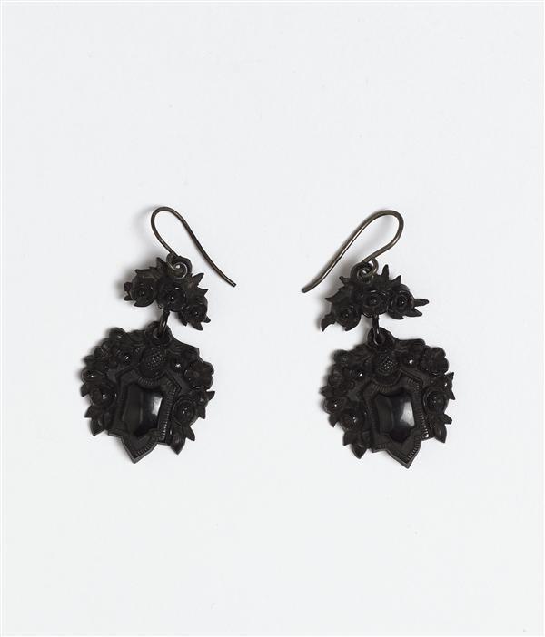 1 paar oorhangers van zwartgeverfd hout(?), gesneden in vorm van schildje met bloemrankjes