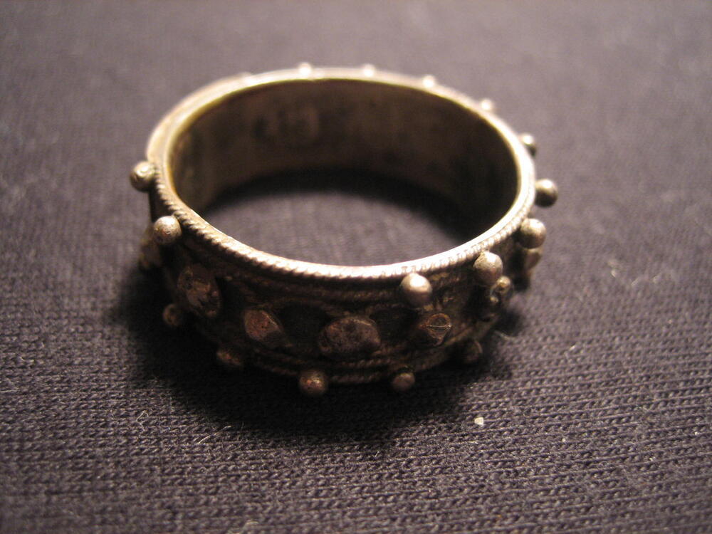 Zilveren 'Akkelde ring'. Rand met stipjes, middenband met rozetjes en knopjes