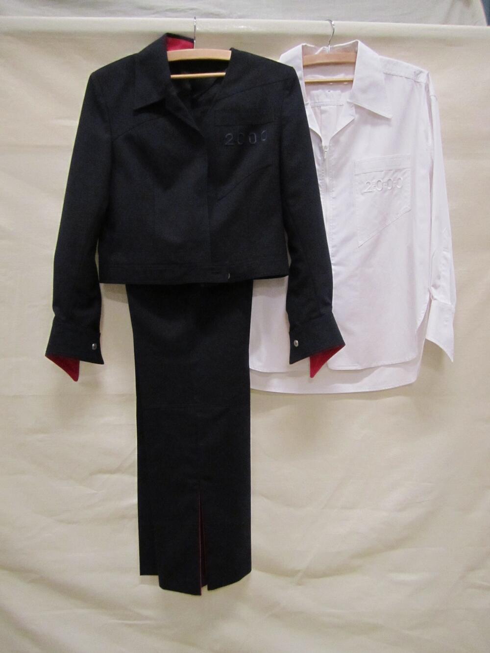 Uniform: jasje en broek van donkerblauw synthetisch kamgaren en felroze accenten, en blouse van wit…