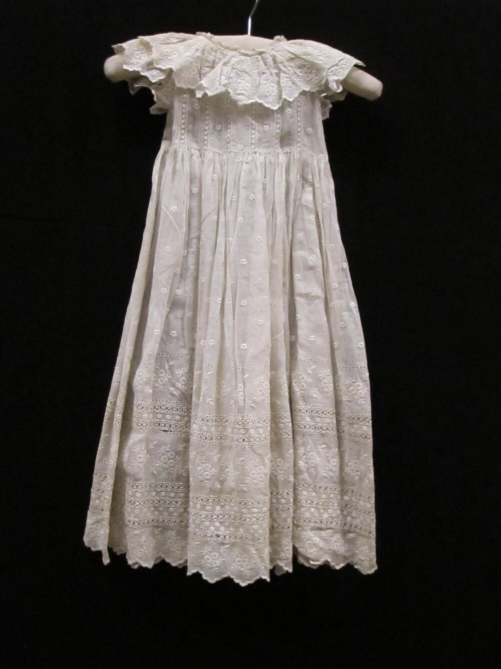 Jurk (kind) van batist, broderie en borduursel of kant / Draagjurk van wit batist, gegarneerd met…