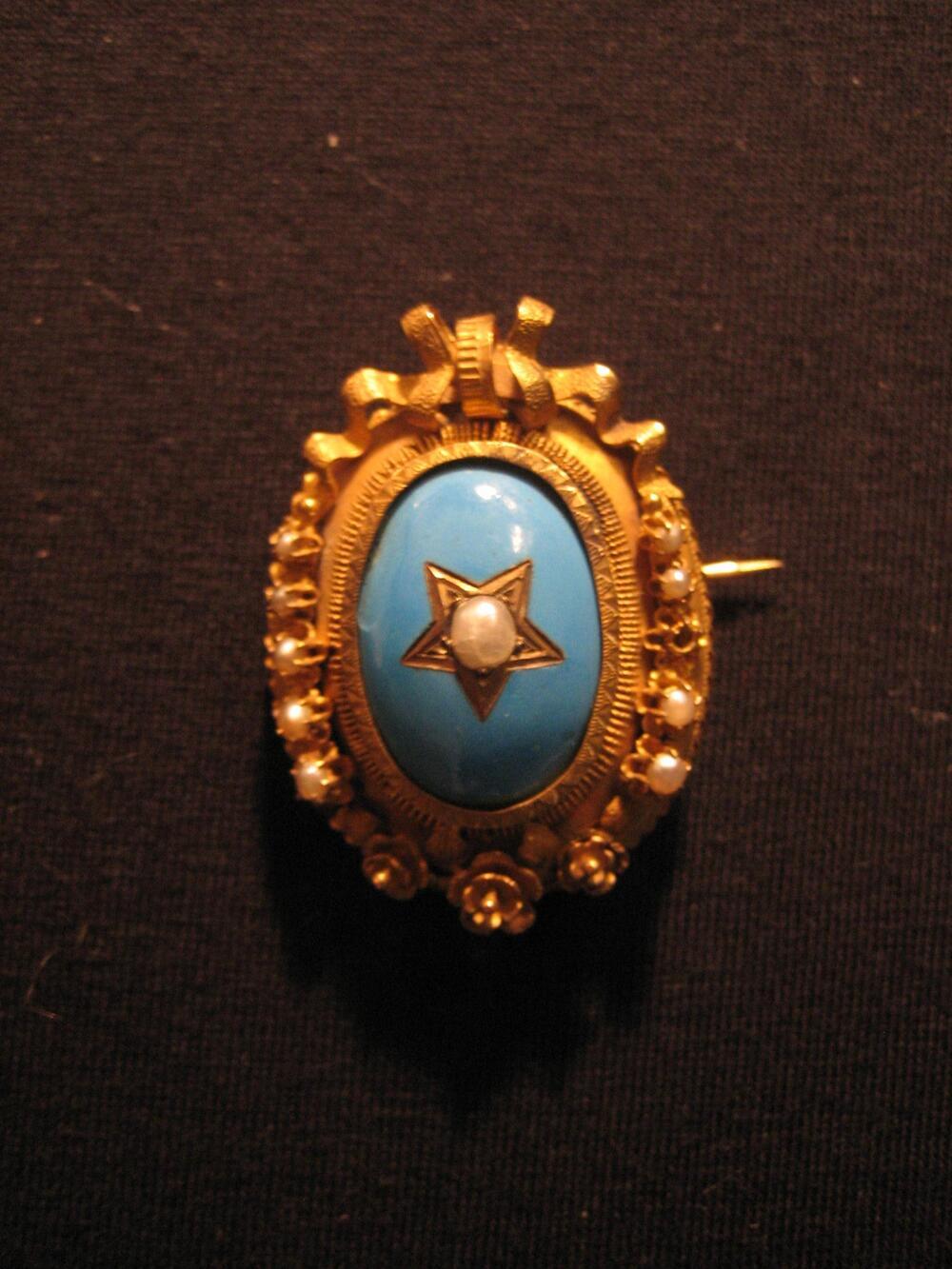 Broche van geelgoud, rondom bezet met steenparels. Ovale broche met bovenaan strikvorm,…
