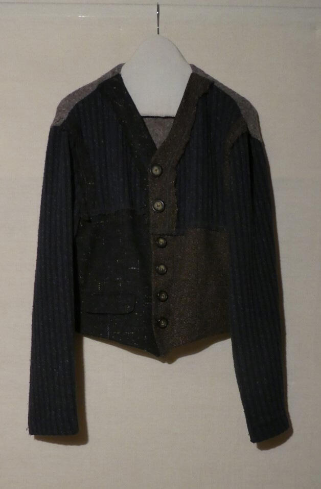 Jasje (man), behorende bij hemd. Voorpand van wollen tweed, mouwen van wollen tricot, in kleuren…